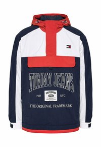 Cortavientos en azul marino, rojo y blanco con medio cierre, bolsillo frontal, logo "TOMMY JEANS" y capucha ajustable con cintas. Tejido texturizado.