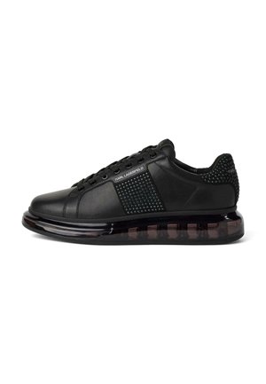 Baskets en cuir noir avec panneau latéral clouté et talon, lacets, semelle épaisse transparente, marquage "Karl Lagerfeld" sur le côté et le talon.
