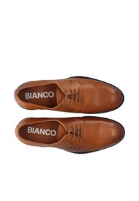 Chaussures en cuir marron à lacets avec une texture lisse, un bout arrondi et des coutures contrastées. Présentent une semelle intérieure de marque avec 'BIANCO'.