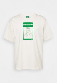 Off-white bomull t-shirt med korta ärmar som har en gröntryckt design av en muskulös karaktär märkt "HULK" på framsidan.