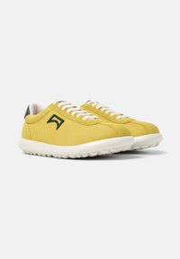 Yellow leather sneakers with white laces and a green accent on the heel. Features a textured sole and a stitched logo on the side.