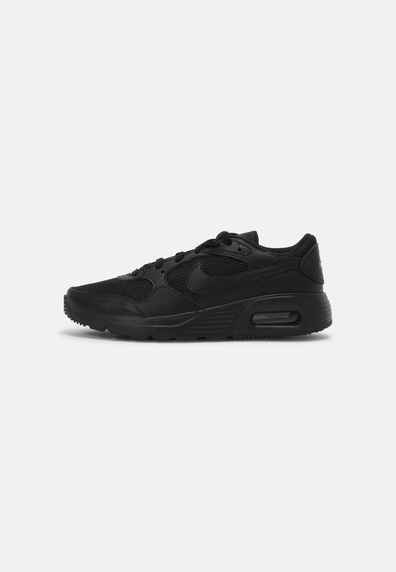 Chaussure de sport noire avec un dessus synthétique texturé, fermeture à lacets, col rembourré et amorti d'air visible dans le talon. Semelle légèrement motif.