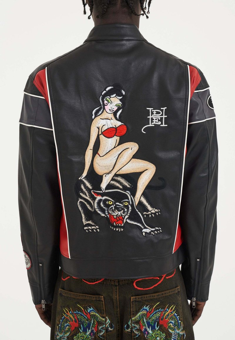 Zwarte leren jack met rode accenten, voorzien van een geborduurde pin-up meisje en een panter op de achterkant, gedetailleerde stiksels en een getailleerd ontwerp.