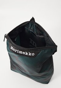 Borsa a motivo nera e teal realizzata in materiale sintetico. Presenta una chiusura con zip superiore e un'etichetta con marchio con testo bianco.