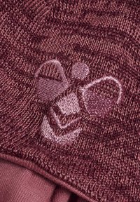 Stickad vinröd tyg med en subtil broderad design av en korg och cirkulära former i en ljusare färg. Mjuk textur, medelhårdhet.