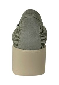 Scarpa verde in suede con una toma in rete texturizzata, design a punta chiusa e tacco a blocco color crema. La parte posteriore mostra una finitura liscia con una leggera curvatura.