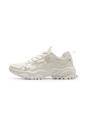 Kremowo-biały, masywny sneaker FILA z teksturowaną podeszwą, sznurowaniem z przodu, wyściełanym kołnierzem i detalami z logo po boku.