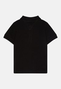 Polo shirt nera con maniche corte e colletto a costine. Realizzata in tessuto texturizzato, presenta una vestibilità classica ed è priva di marchi o motivi visibili.