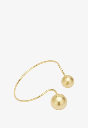 Zelta metāla aproce ar diviem gludiem sfēriskajiem akcentiem katrā galā. Dizains ir minimālistisks un izliekts.