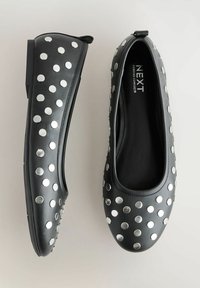 Melni dzīvokļi ar sudraba metāliskiem punktiņiem, viegls dizains, apaļa pēda un gluda ādas apdare. Ir cilpa ērtai uzvelkšanai.