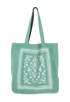 Grøn stoftaske med hvidt blomsterprint i midten og to lange skulderstropper.