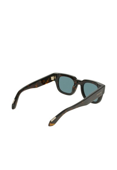 Lunettes de soleil en écaille de tortue avec des verres bleus, des montures carrées et des branches élégantes ornées d'accents argentés. Finition texturée sur la monture.