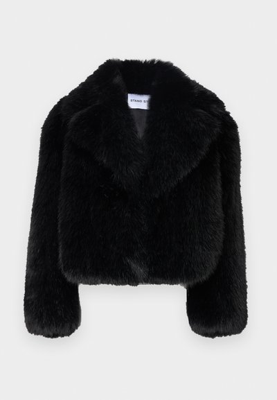 Veste courte en fausse fourrure noire avec col à revers, manches longues et finition douce et texturée. Étiquette avec "STAND ST."