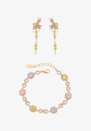 Złote kolczyki w kształcie motyla z żółtymi i przezroczystymi kryształami, zestawione ze złotą bransoletką zdobioną różowymi, żółtymi i fioletowymi okrągłymi kamieniami szlachetnymi.