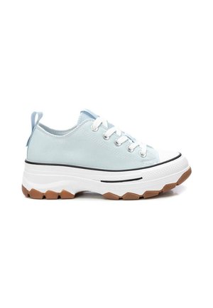Zapatilla deportiva de lona azul claro con cordones blancos, suela blanca gruesa, suela exterior de goma marrón texturizada y pestaña en el talón.