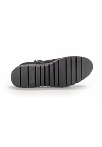 Semelle de chaussure noire avec de profondes rainures horizontales, surface texturée et nom de marque "Gabor" embossé près du talon.
