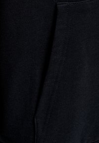 Marinblå sweatshirt med ribbad textur; synlig sidovertägg och fickdetalj; mjukt, stretcht material.