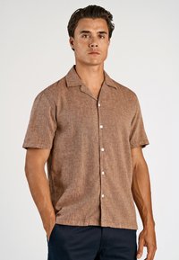 Kurzärmliges Hemd mit Knopfleiste aus braunem strukturiertem Stoff mit subtilischem Muster, mit klassischem Kragen und weißen Knöpfen.