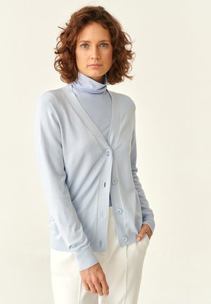 Heledad sinine kardigan, mis on valmistatud pehmest materjalist, V-kaelusega, nööbiga kinnitatav ja pika varruka ning mille peal on vastav turtleneck.
