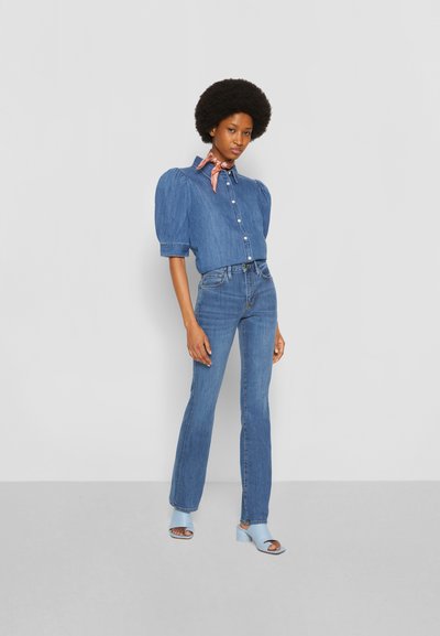 Denim krekls ar pūkām, pogu aizdare, kombinēts ar gaiši ziliem flared džinsiem un ziliem augstpapēžu sandaļiem. Zīda šalle koralltoņos.