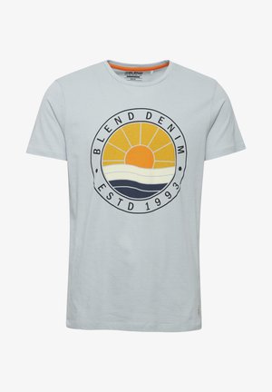 Világoskék pamut póló, kör alakú grafikával, ami egy sárga napot, fehér és sötétkék hullámokat tartalmaz, valamint a "BLEND DENIM ESTD 1993" feliratot.