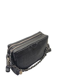 Sac à main en cuir tressé noir avec deux compartiments zippés, une bandoulière en chaîne tressée et une petite étiquette en métal ronde de marque.