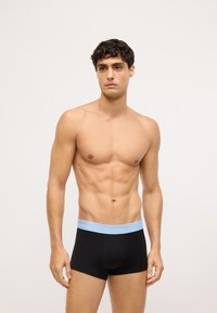 Čierne bavlnené boxerky s ľahko modrým pásom Calvin Klein, s priliehavým strihom a hladkou textúrou.