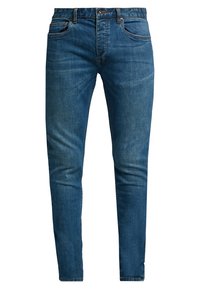 Jeans de hombre de corte ajustado en denim azul con una ligera textura descolorida, bolsillos frontales, presillas para cinturón y cierre de botón en la cintura.