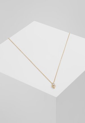 Collier délicat en chaîne d'or avec un petit pendentif géométrique comportant une pierre précieuse claire ronde et triangulaire sur une surface blanche.