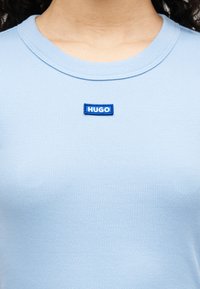 Γαλάζιο ριμπ κοντομάνικο μπλουζάκι από μαλακό βαμβάκι, με στρογγυλή λαιμόκοψη και μπλε κεντημένο λογότυπο "HUGO" στο στήθος.