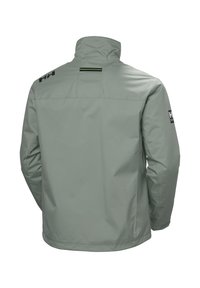 Lichtgroene waterdichte jas met hoge kraag, voorzien van zwarte logo-accenten en een stijlvolle, gladde textuur. De achterkant toont minimale naden.