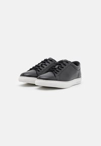 Black leather sneakers with a smooth texture, featuring a white rubber sole, round toe, and traditional lace-up design.