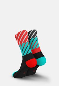Bunte Socken mit diagonalen Streifenmustern in Rot, Schwarz, Türkis und Akzenten. Das Material ist weich, mit kontrastierenden Farben an Zehen und Ferse.