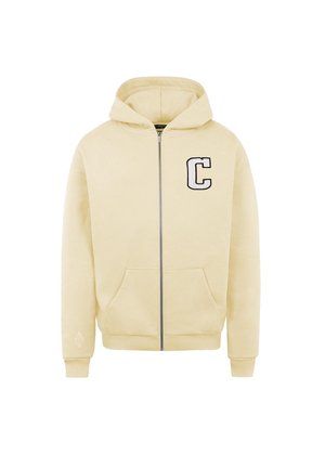 Light yellow zip-up hoodie with front pockets, hood, and a large black "C" on the left chest. Soft fabric with ribbed cuffs and hem.