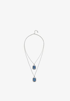 Collier à double chaîne en argent avec deux pierres précieuses rectangulaires bleues, un pendentif légèrement plus court que l'autre, design minimaliste.