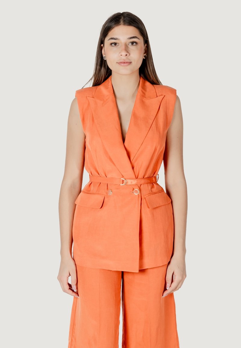 Blazer arancione senza maniche con vita cintata, due tasche frontali e vestibilità sartoriale, abbinato a pantaloni a gamba larga coordinati.