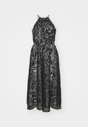 Robe noire à col halter avec des détails en dentelle intricats, une taille cintrée avec une ceinture, et une jupe fluide qui tombe jusqu'aux chevilles.