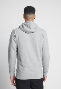 Szara bluza z kapturem, z długimi rękawami, ściągaczami przy rękawach i na dole. Gładka tekstura, z klasycznym kapturem i minimalnym wzornictwem.