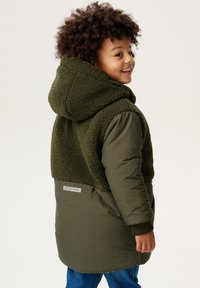 Manteau vert olive avec une capuche en polaire et un haut en polaire, section inférieure lisse et poignets côtelés. Étiquette au dos indiquant "NPPS OUTDOORS."