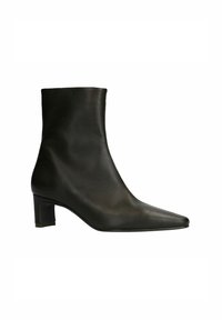 Bottine en cuir noir avec bout pointu et talon bloc. Texture lisse, design minimaliste, hauteur mi-mollet, sans pièces métalliques visibles.