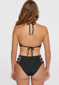 Zwart bikini set met een haltertop met strikrug en hooggewijze broek met zijuitsparingen. Vlotte textuur, minimalistisch ontwerp.