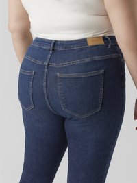Donkerblauwe denim spijkerbroek met een slim-fit, voorzien van een mid-rise taille, twee achterzakken, lichte stiksels en een nep leren label aan de achterkant.