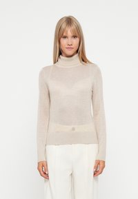 Pull en col roulé beige en tissu léger et transparent. Il dispose de manches longues et de poignets côtelés, avec une silhouette ajustée et une texture subtile.