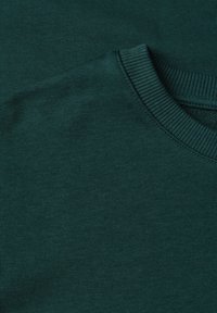 Pull vert foncé col rond avec col côtelé, présenté à plat avec un focus sur l'épaule et la zone de l'encolure.