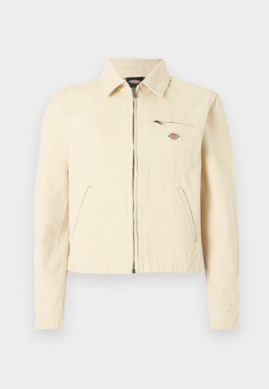 Helebeež zipitud jakk kraega, kahe nurga all küljetaskuga ja ühe lukuga rinnataskuga, millel on väike brändilogoga silt.