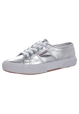 Zapatilla deportiva plateada metálica de corte bajo con cordones blancos, suela de goma y logo de Superga en el lateral.