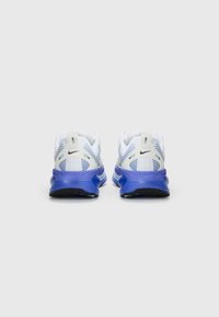 Adidași de alergare Nike cu un mesh alb, accentuat cu detalii albastre și o talpă texturată de culoare mov, proiectați pentru confort și stabilitate.