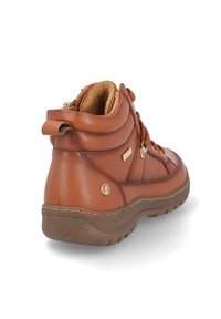 Botas de tobillo de cuero marrón con un diseño texturizado, collar acolchado, herrajes metálicos y una suela de goma con relieve.