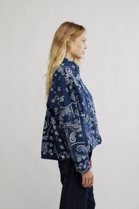 Tumesinist värvi särk, millel on valge paisleimuster, nööbitav eesmine osa ja pikad varrukad. Valmistatud pehmest kangast, lõdva istuvusega ja küljetaskutega.