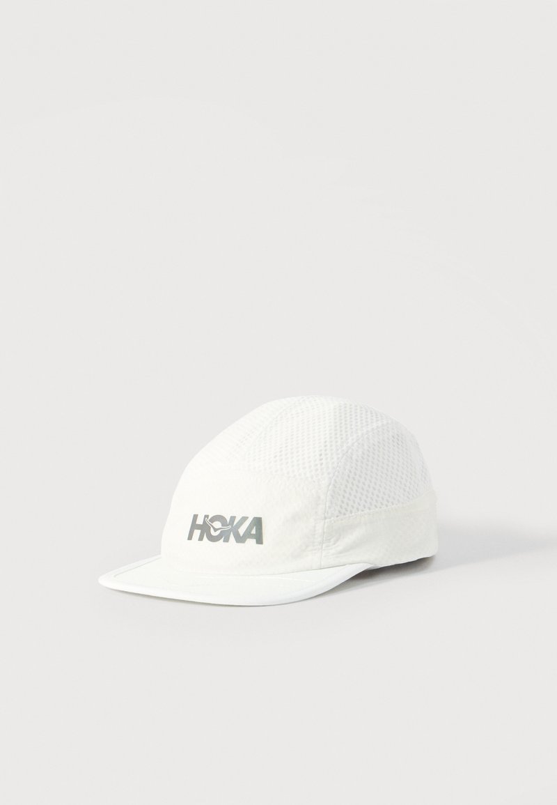 Λευκό δίχτυ τρέξιμου καπέλο με κυρτό γείσο και ανακλαστικό λογότυπο "HOKA" στο μπροστινό πάνελ, τοποθετημένο σε απλό φόντο.